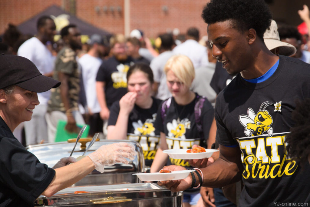 A student receives hot wings and other food on State Stride day. (Jon Musselwhite/YJ Online)