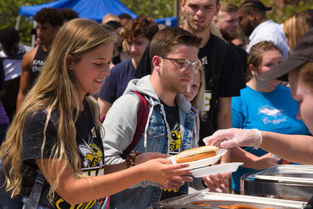 A student receives hot dogs and other food on State Stride day. (Jon Musselwhite/YJ Online)