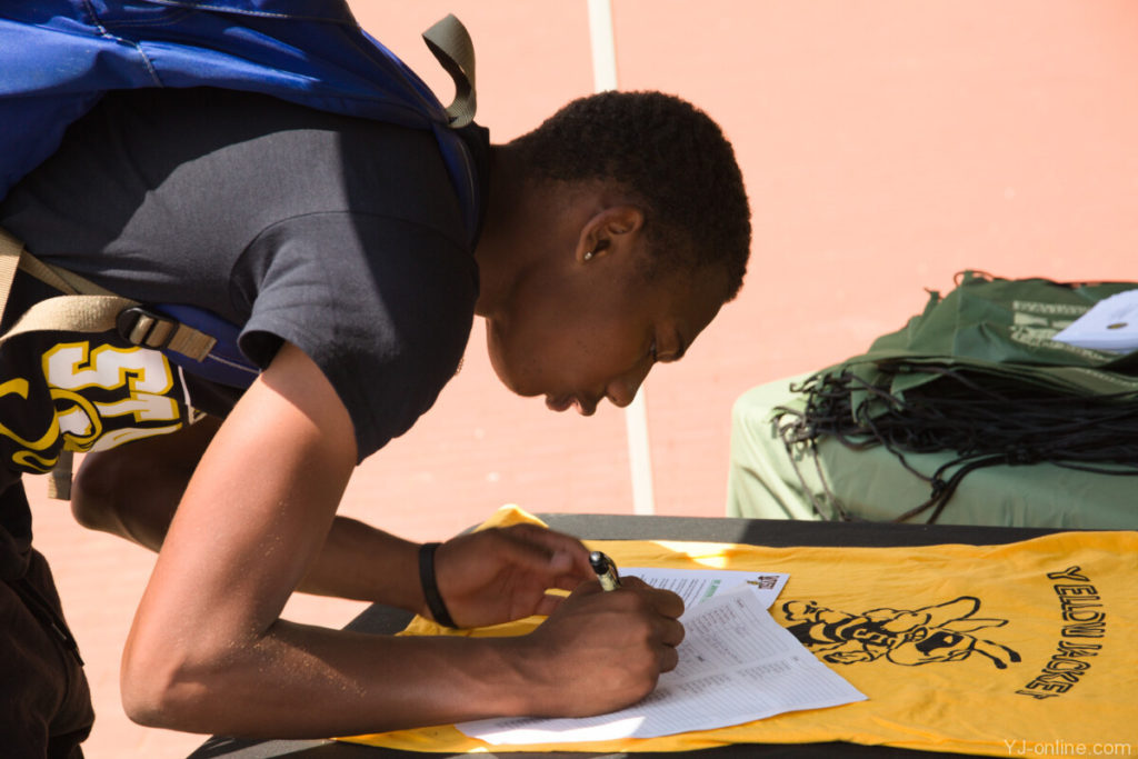 A student signs up for more information about an organization on State Stride day. (Jon Musselwhite/YJ Online)
